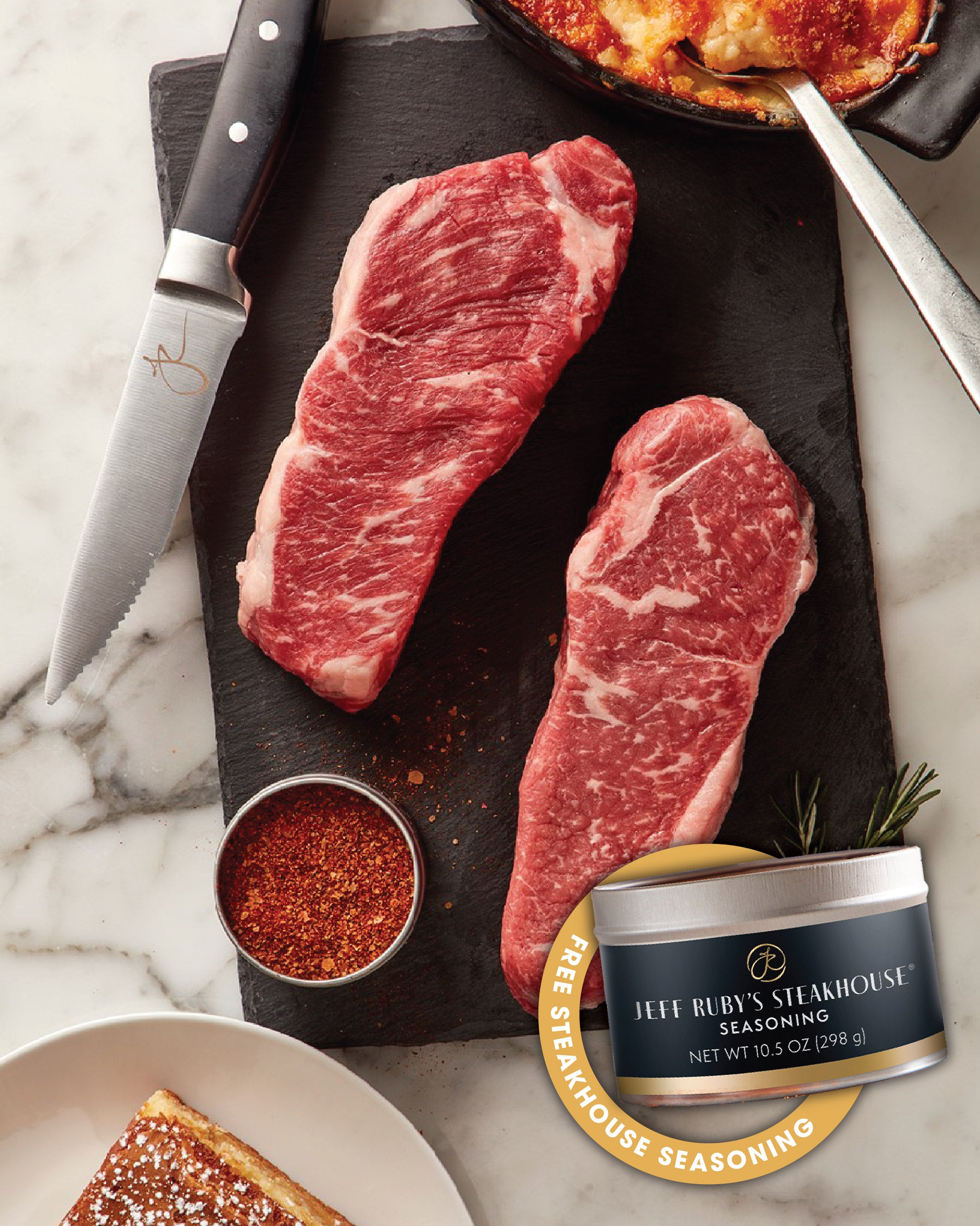 Two raw Jeff Ruby's steaks on a cutting board with a can of Jeff Ruby's Steakhouse seasoning.